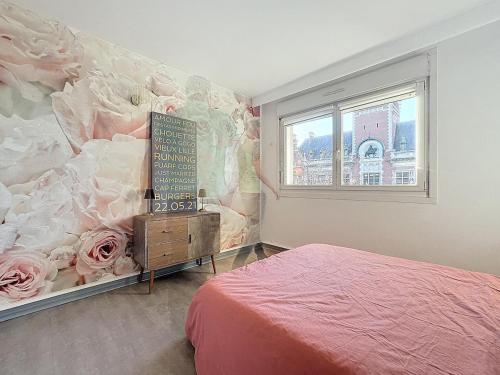 - une chambre avec un lit et un mur orné de fleurs dans l'établissement Le balcon, à Dunkerque