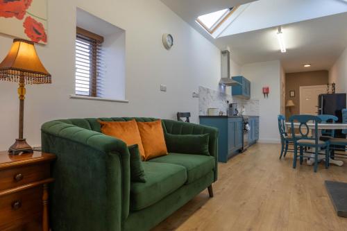 a living room with a green couch and a table at Tigin Dingle in Dingle