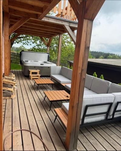 a patio with a couch and tables on a deck at Apartmán Horský Sklípek in Trutnov