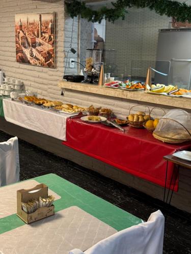 a buffet with a red table with food on it at Pousada Vila Italia - Porto da Dunas in Aquiraz