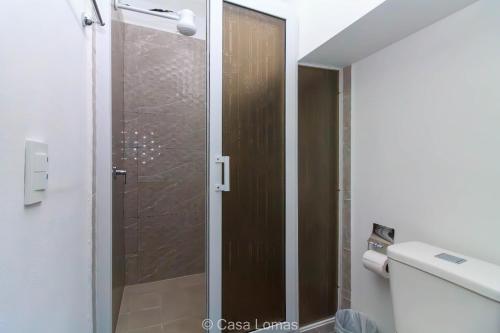 a bathroom with a shower with a glass door at Casa Lomas in Tegucigalpa