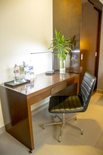 a desk with a chair and a plant on it at Hotel Las Cascadas in San Pedro Sula