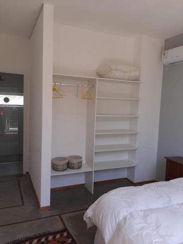 a bedroom with white shelves and a bed at Casa de artista in Colonia del Sacramento