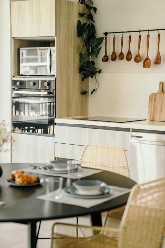 a kitchen with a table and chairs and a microwave at LUXURY Apartment in BLUE Playa Venao B-32 in Playa Venao