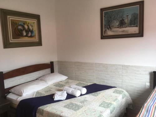 a bedroom with two beds and two pictures on the wall at Pouso do Elefante in Serra do Cipo