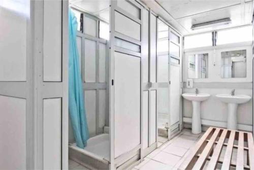 a white bathroom with a sink and a shower at Cozy Lisbon Marina Sleepaboard - Sail Away in Lisbon