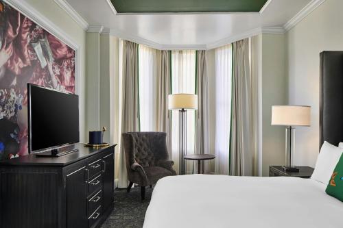 a hotel room with a bed and a flat screen tv at Le Pavillon, New Orleans, a Tribute Portfolio Hotel in New Orleans