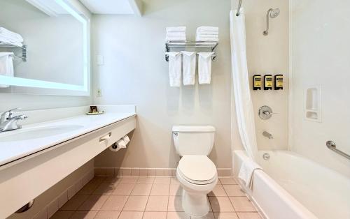 a bathroom with a toilet and a sink and a tub at Best Western Plus Suites Hotel - Los Angeles LAX Airport in Inglewood
