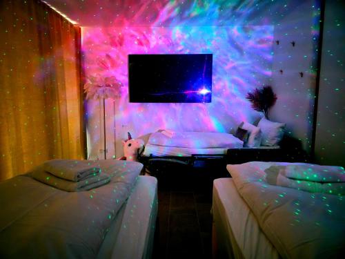a room with two beds and a tv in it at TROPICAL ISLAND 23C - Seesicht - Massage - BBQ - Billiard - Tischkicker - Penthouse - Parkplatz in Öhningen