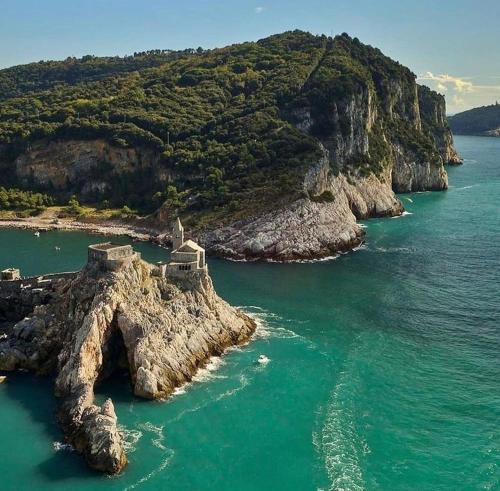 an island in the ocean with a house on it at La Lucetta in Le Grazie