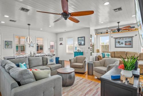 a living room with couches and a ceiling fan at No Regrets PET FRIENDLY in Port Aransas