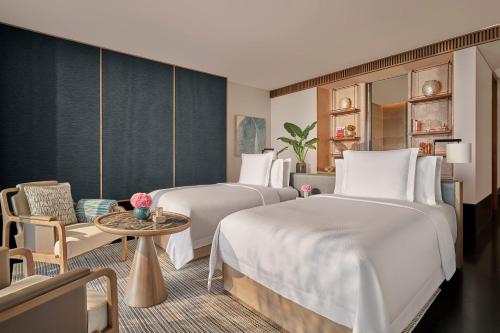 a hotel room with two beds and a table at Regent Phu Quoc in Phu Quoc