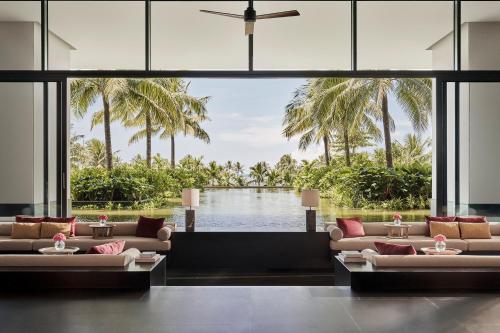 a living room with couches and a pool at Regent Phu Quoc in Phu Quoc