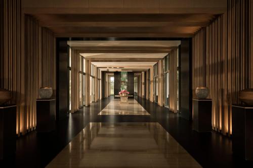 a hallway of a building with a plant in the distance at Regent Phu Quoc in Phu Quoc