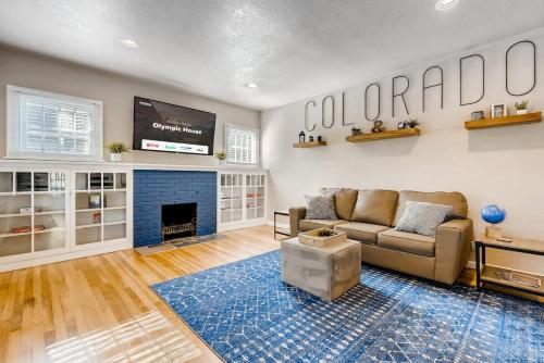 a living room with a couch and a tv at Olympic House Downtown w Hot Tub Fire pit & BBQ in Colorado Springs