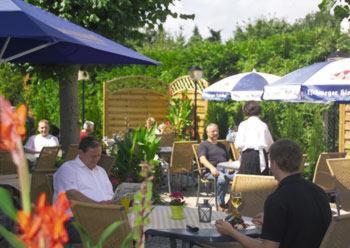 Un groupe de personnes assises à des tables sous des parasols dans l'établissement Hotel zur Struth, à Eschwege