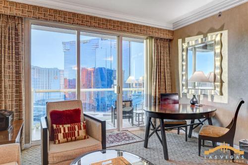 a living room with a table and a large window at MGM Signature-22-615 Strip View Balcony Studio in Las Vegas