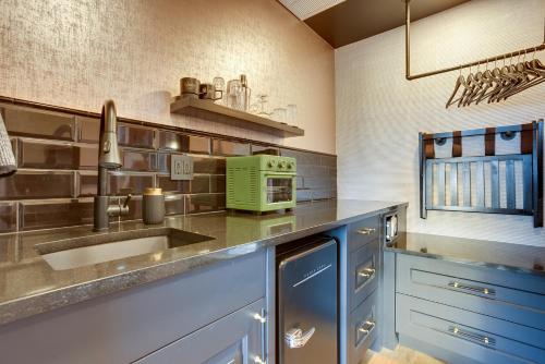 a kitchen with blue cabinets and a sink at The Reed at The Louie Boutique Motel, Private Sauna! Walk to Everything! in Newport