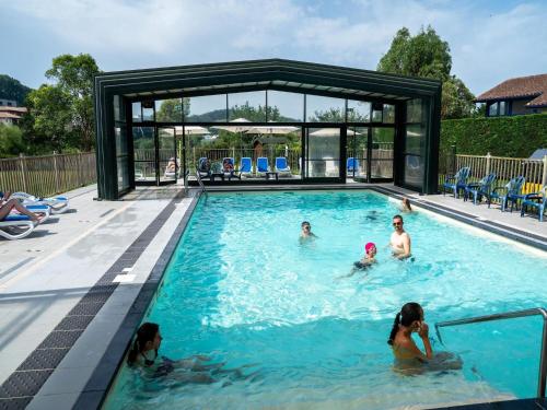 un groupe de personnes dans une piscine dans l'établissement Apartment in Urrugne with Ocean Views, à Socoa