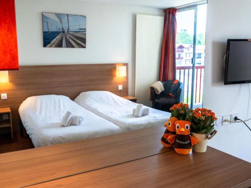 une chambre d'hôtel avec un lit et des fleurs sur une table dans l'établissement Apartment in Urrugne with Ocean Views, à Socoa