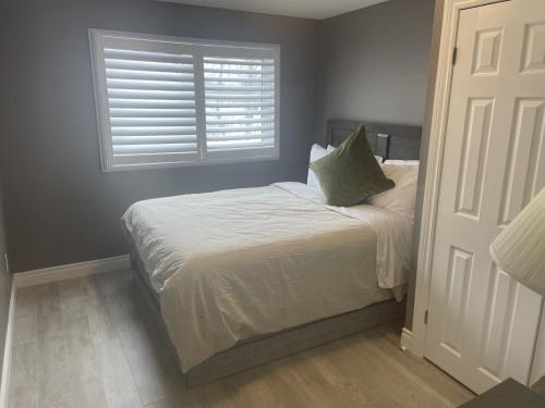 a small bedroom with a bed with a window at Country in the City - Wonderful Complimentary Breakfast Delivered Daily to House in Niagara Falls