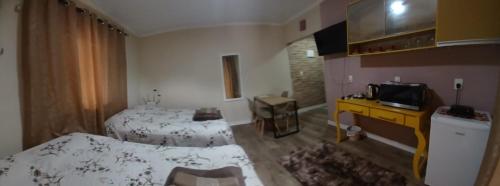a hotel room with two beds and a television at Loft Confort in Pomerode