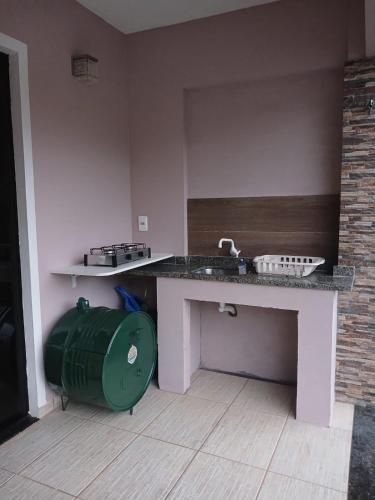 a kitchen with a sink and a green trash can at Loft Confort in Pomerode