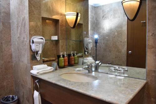 a bathroom with a sink and a large mirror at Holiday Inn & Suites Batangas LimaPark by IHG in Batangas City