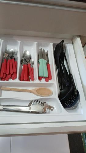 a drawer filled with utensils in a cabinet at MALIA MURO ALTO STUDIO 300m DO MAR in Porto De Galinhas