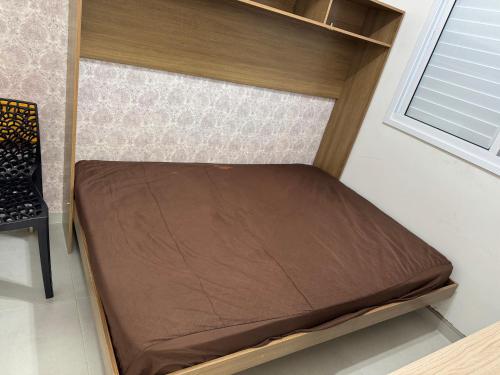 een klein bed in een kamer met een raam bij Lazer completo e vista inesquecível in Guarujá