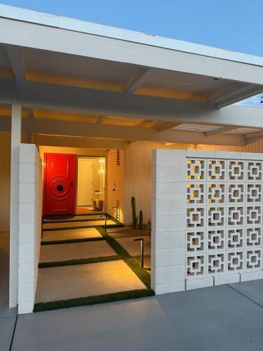 a house with a red door and a fence at Aerhaus - Mid-Century Oasis in Palm Springs