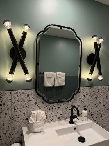 a bathroom with a sink and a mirror at Aerhaus - Mid-Century Oasis in Palm Springs