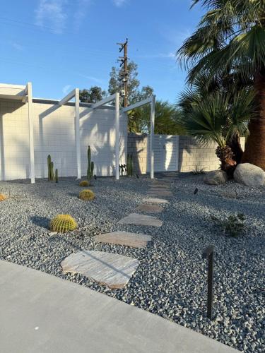 a garden with rocks and a fence and a gate at Aerhaus - Mid-Century Oasis in Palm Springs
