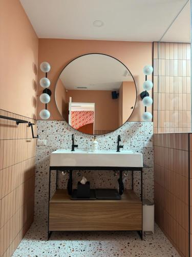 a bathroom with a sink and a mirror at Aerhaus - Mid-Century Oasis in Palm Springs