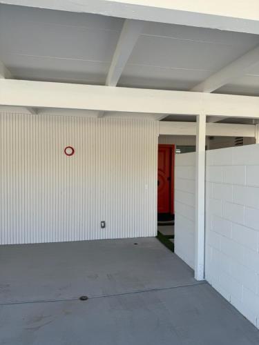 an empty garage with a red sign on the wall at Aerhaus - Mid-Century Oasis in Palm Springs