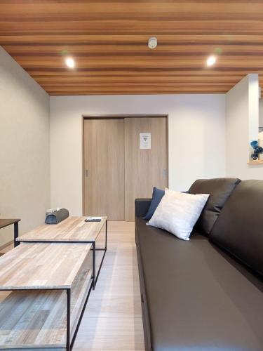 a living room with a couch and a wooden ceiling at THE TERRAce HAKATA in Fukuoka