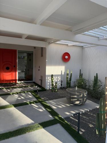 a courtyard with a red door and cactus at Aerhaus - Mid-Century Oasis in Palm Springs