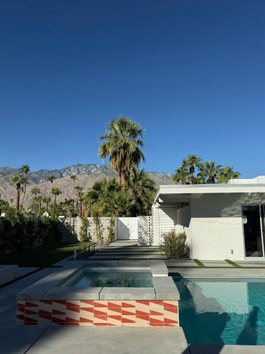 a house with a swimming pool in front of a house at Aerhaus - Mid-Century Oasis in Palm Springs