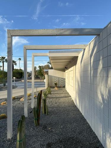 a white building with awning next to a street at Aerhaus - Mid-Century Oasis in Palm Springs
