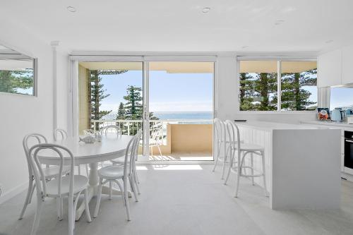 a kitchen and dining room with a table and chairs at Premium Beachfront with Unbelievable Views in Sydney