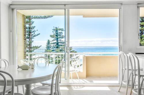 a dining room with a table and chairs and a view of the ocean at Premium Beachfront with Unbelievable Views in Sydney
