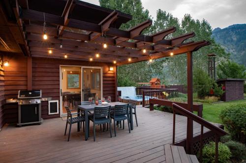 a deck with a table and chairs under a pergola at Alpine Highmark in Alpine