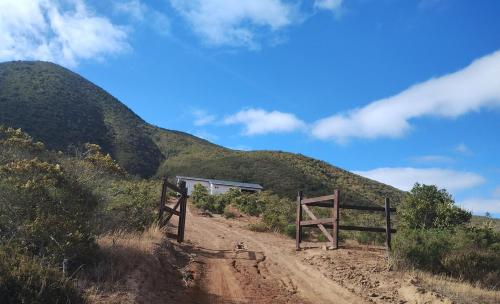 a dirt road with a fence and a mountain at Casa parcela en Quilimari a 20 minutos de playa Pichidangui in Quilimarí