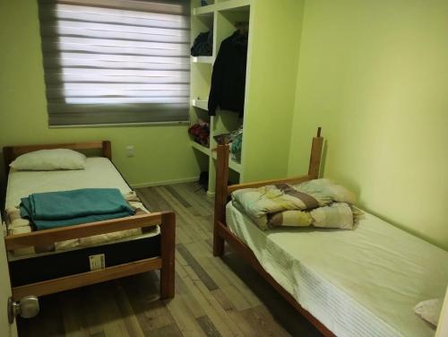 two twin beds in a room with a window at Casa parcela en Quilimari a 20 minutos de playa Pichidangui in Quilimarí