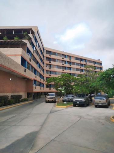 a parking lot with cars parked in front of a building at Apartamento Punta Brava en el Centro de Tucacas in Tucacas