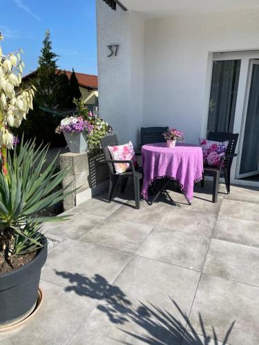 a purple table and chairs on a patio with flowers at SECRA Exclusive Zum Sternberg in Münsingen