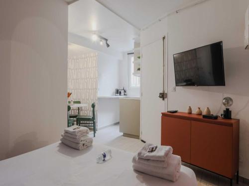 un salon avec une télévision à écran plat sur un mur dans l'établissement Welcoming Studio for 2 people - Épinettes, à Paris