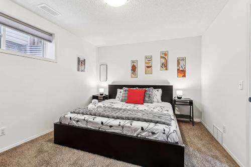 カルガリーにあるBasement Suite in Calgary - Short Drive to Banffのベッドルーム1室(赤い枕付きのベッド1台付)