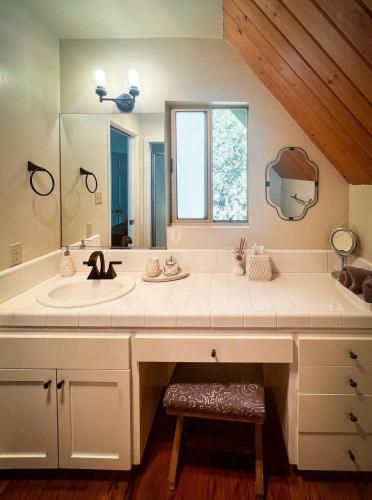 a bathroom with a sink and a mirror at Stunning secluded Creekside A-Frame gameroom in Lake Arrowhead