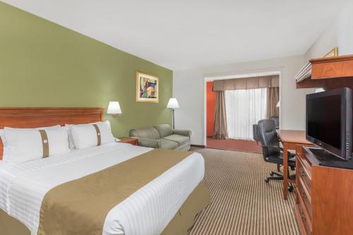 a hotel room with a bed and a flat screen tv at Wyndham Garden Obregon in Ciudad Obregón